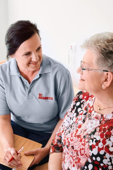 Johanniter-Pflegerin im Gespräch mit Kundin und Tochter