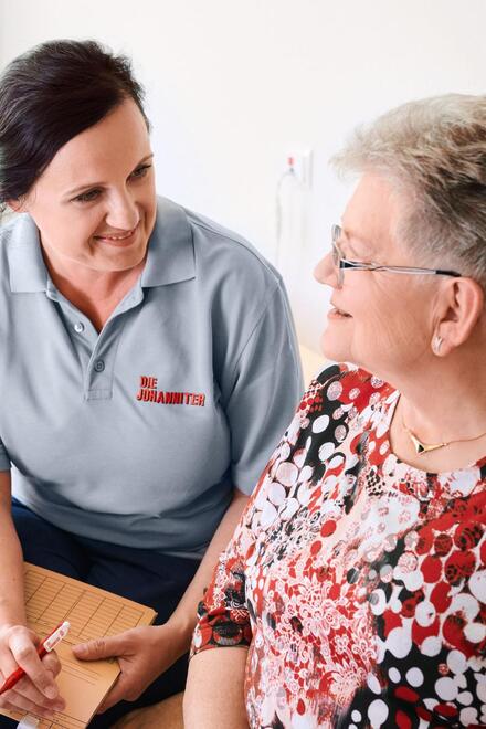 Johanniter-Pflegerin im Gespräch mit Kundin und Tochter