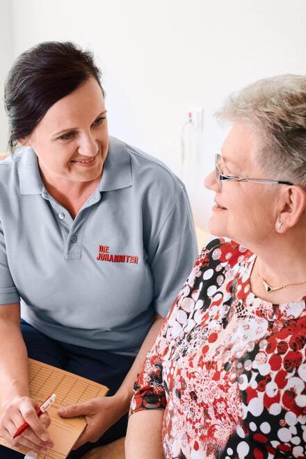 Johanniter-Pflegerin im Gespräch mit Kundin und Tochter