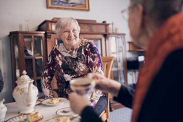 Eine Bewohnerin gießt Kaffee in eine antike Tasse