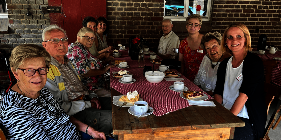 Menschen am gedeckten Kaffeetisch