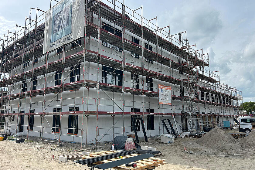 Ein Gebäude im Rohbau mit Gerüsten.