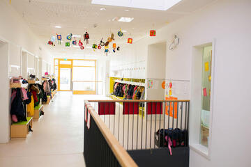 Flur in Kita mit bunten Kinderjacken und Spinden der Kinder