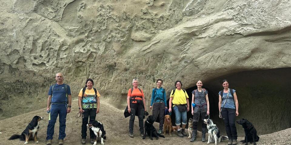 Team der Rettungshundestaffel posiert ganz privat in Mayen vor einer Trasshöhle mit ihren Hunden