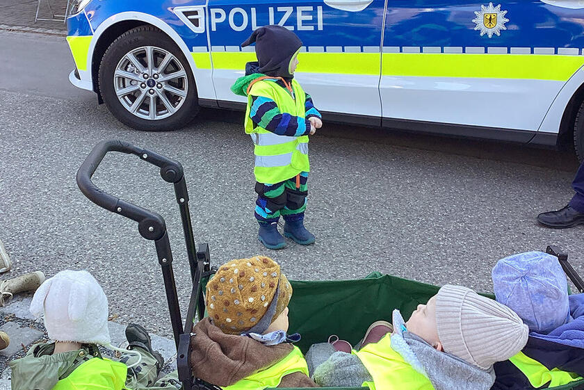Ein Polizeiwagen besucht die Krippenkinder der Biberbande