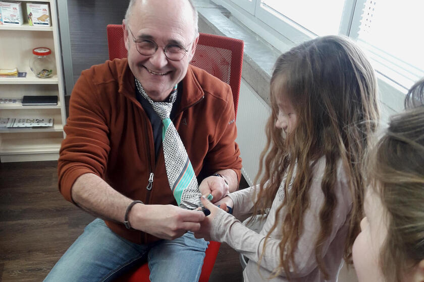 Mädchen schneidet an Fasching Krawatte ab