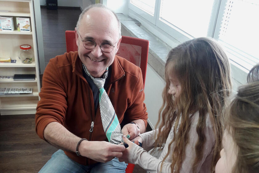 Mädchen schneidet an Fasching Krawatte ab