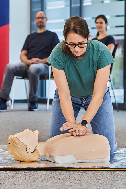 Eine Kursteilehmerin führt Erste Hilfe Maßnahmen an einer Puppe durch