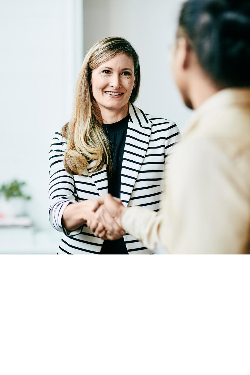 Eine Frau reicht einer anderen Person ihre Hand.