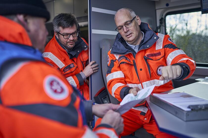 Einsatzbesprechung im Team der Rettungshundestaffel in einem Fahrzeug.
