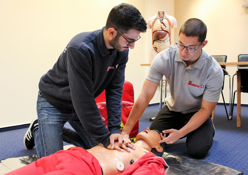 In einem Erste-Hilfe-Kurs für Betriebshelfer übt ein Teilnehmer an einer Puppe die Herz-Lungen-Wiederbelebung.