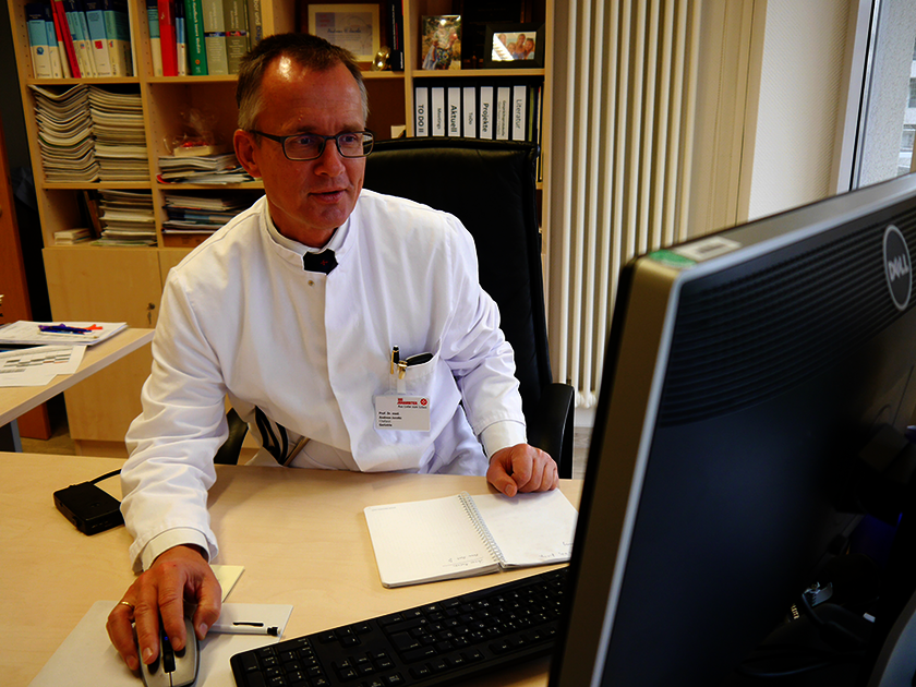 Dr. Jacobs, Chefatzt der Geriatrie und Neurologie am Waldkrankenhaus Bonn bei der Erstellung eines geriatrischen Therapieplans eines älteren Patienten.