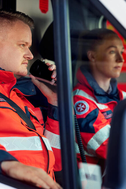 Zwei Rettungskräfte der Johanniter in einem Fahrzeug