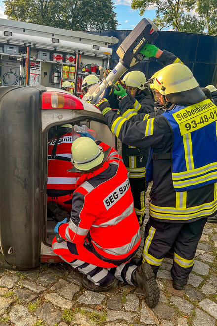 Übung der Schnell-Einsatz-Gruppe Sanität mit der Feuerwehr: Sanitätshelfer unterstützen die Feuerwehr bei der Befreiung einer Person in einem verunfallten Auto und übernehmen die Erstversorgung.