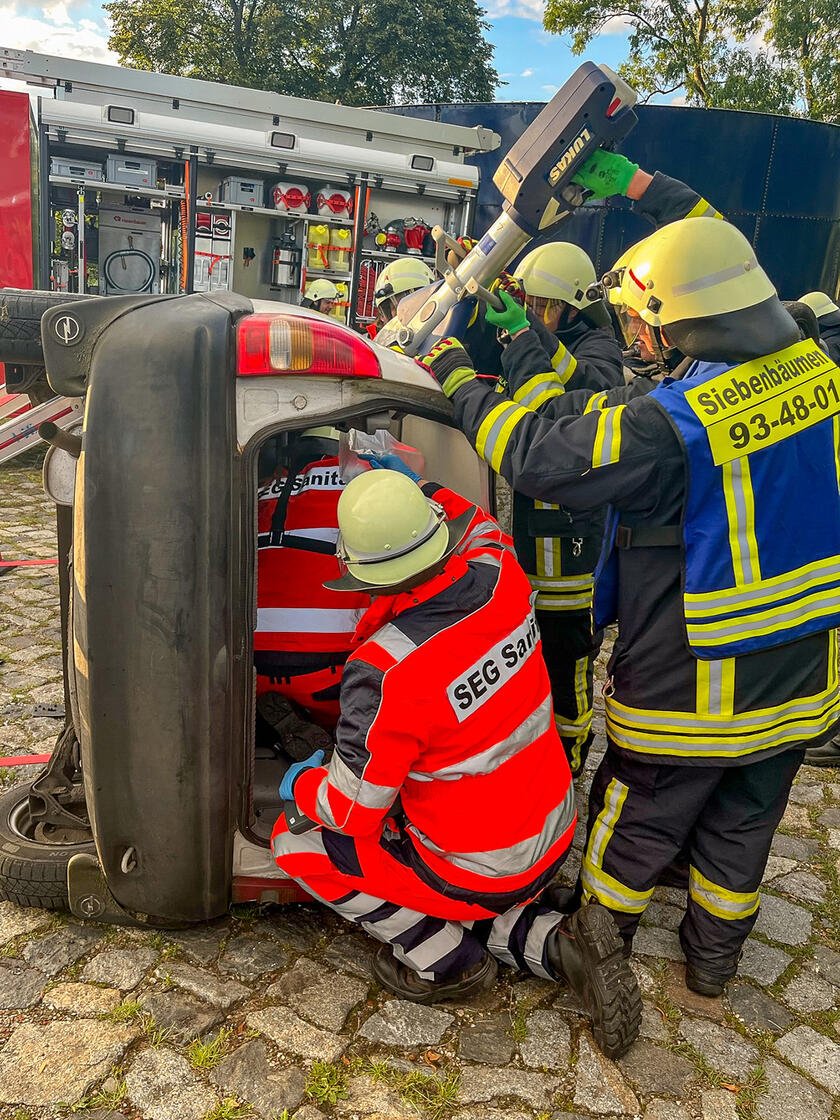 Übung der Schnell-Einsatz-Gruppe Sanität mit der Feuerwehr: Sanitätshelfer unterstützen die Feuerwehr bei der Befreiung einer Person in einem verunfallten Auto und übernehmen die Erstversorgung.
