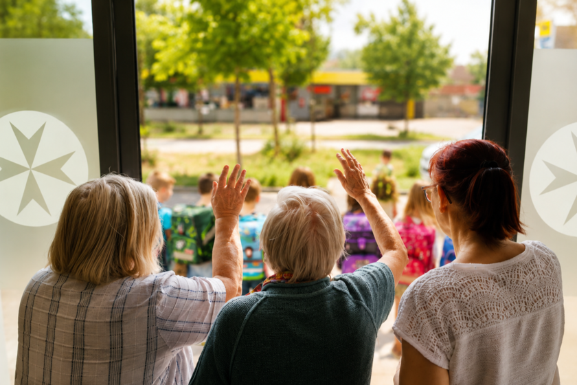 Seniorinnen winken Vorschulkindern