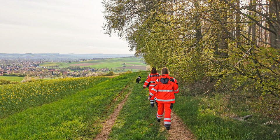 Zwei Mitglieder der Rettungshunestaffel mit Hund auf der Suche