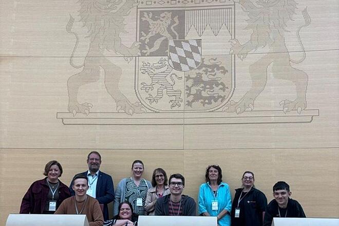 Zehn Mitarbeitende der Johanniter Mittelfranken durften den Bayerischen Landtag besuchen. Gemeinsam machten sie ein Gruppenfoto im Plenarsaal. 