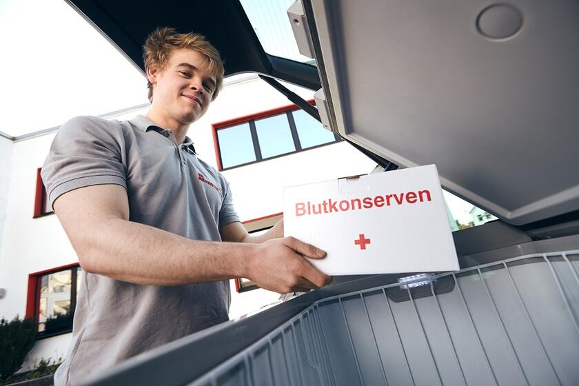 FSJler lädt Transportbox für Blutkonserven ins Auto