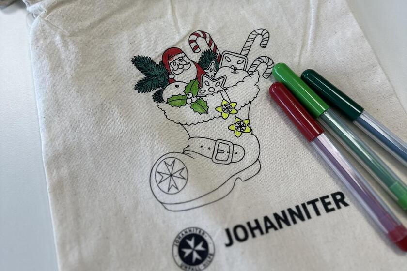 Baumwollsäckchen mit einem Nikolausstiefel bedruckt darauf liegen Filzstifte