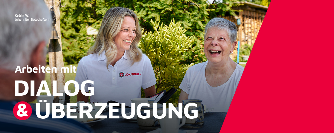 Eine Johanniter-Botschafterin im Gespräch mit zwei Senioren im Garten.