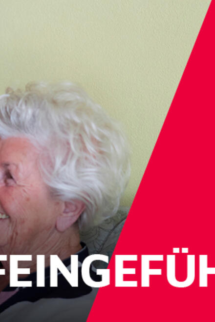 Eine Pflegefachkraft in der Altenpflege im Gespräch mit einer Klientin.