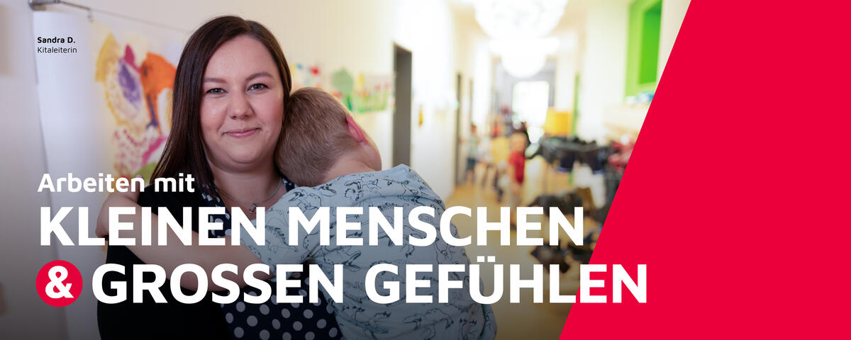 Die Leiterin einer Johanniter-Kita hält ein Kind auf dem Arm.